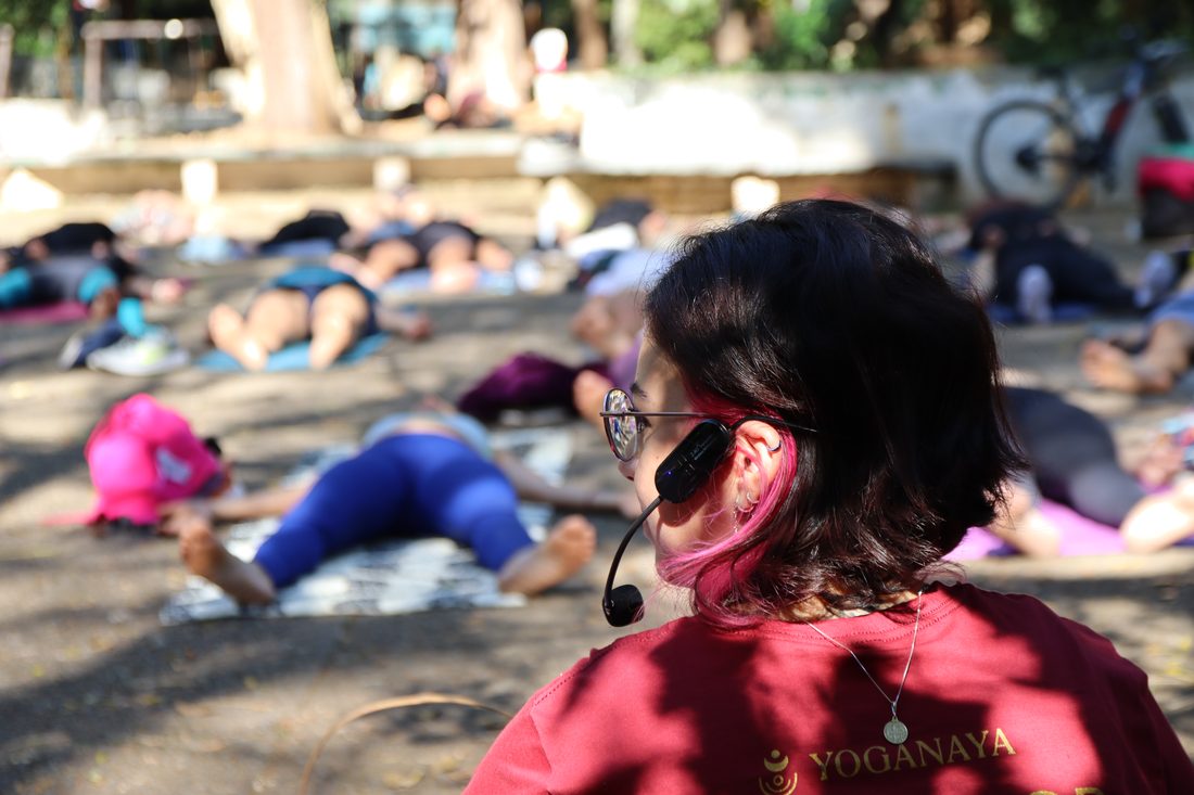 Instrutora conduzindo uma aula de yoga ao ar livre